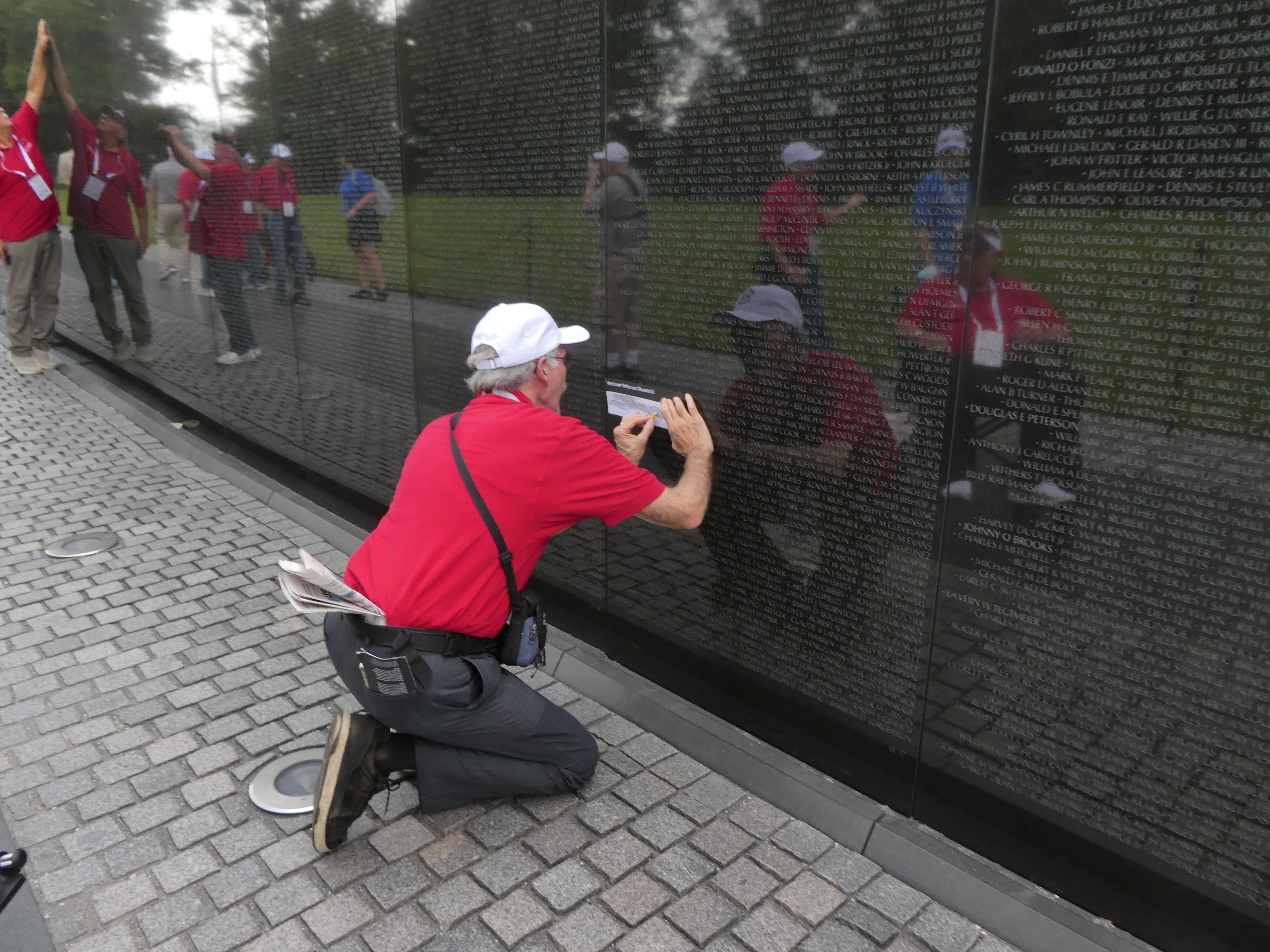 John takes an etching from the Vietnam Wall 