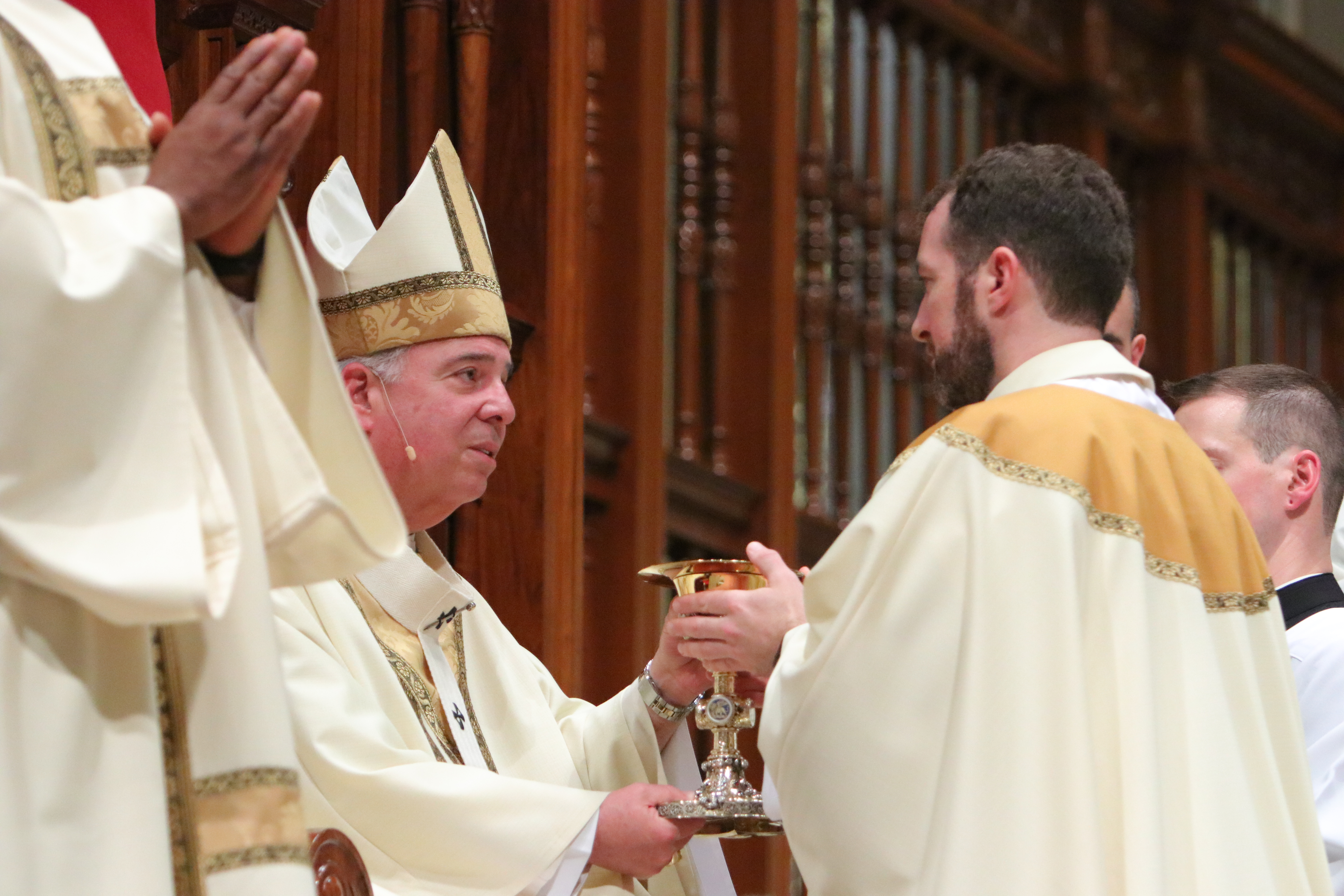 Father Henry Graebe receives the chalice and paten